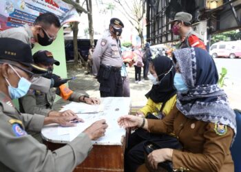 TIDAK MENGENAKAN MASKER. Seorang ASN terjaring razia yustisi karena tidak mengenakan masker di Jalan Raden Intan, Tugu Adipura, Bandar Lampung, Senin (1/2). Bagi warga yang melanggar protokol kesehatan diberikan hukuman fisik dan menandatangani surat teguran tertulis dari Pemerintah Kota Bandar Lampung.
LAMPUNG POST/ZAINUDDIN