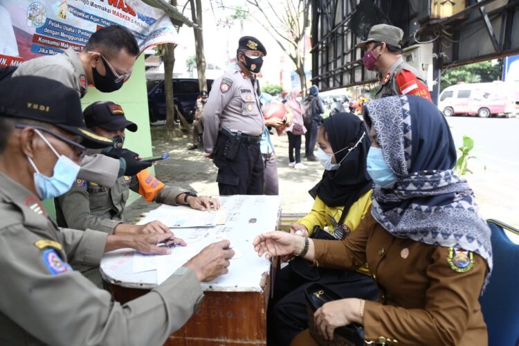 TIDAK MENGENAKAN MASKER. Seorang ASN terjaring razia yustisi karena tidak mengenakan masker di Jalan Raden Intan, Tugu Adipura, Bandar Lampung, Senin (1/2). Bagi warga yang melanggar protokol kesehatan diberikan hukuman fisik dan menandatangani surat teguran tertulis dari Pemerintah Kota Bandar Lampung.
LAMPUNG POST/ZAINUDDIN