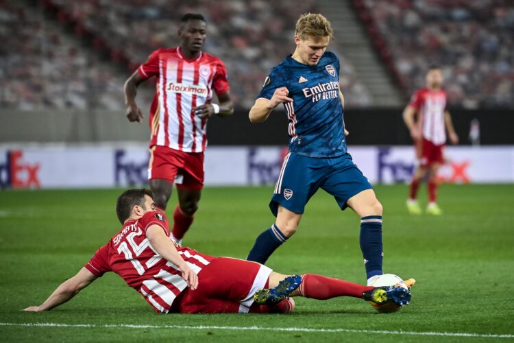 ARSENAL KALAHKAN OLYMPIAKOS 3-1. Bek Olympiakos Sokratis Papastathopoulos (bawah) berusaha merebut bola dari penyerang Arsenal Martin Odegaard (kanan) saat leg pertama 16 besar Liga Eropa di Stadion Georgios Karaiskakis, Piraeus, Yunani, Jumat (12/3). Duo Gol perdana Martin Odegaard bersama Arsenal mewarnai kemenangan 3-1 yang dibukukan The Gunners di markas Olympiakos.
AFP/ARIS MESSINIS