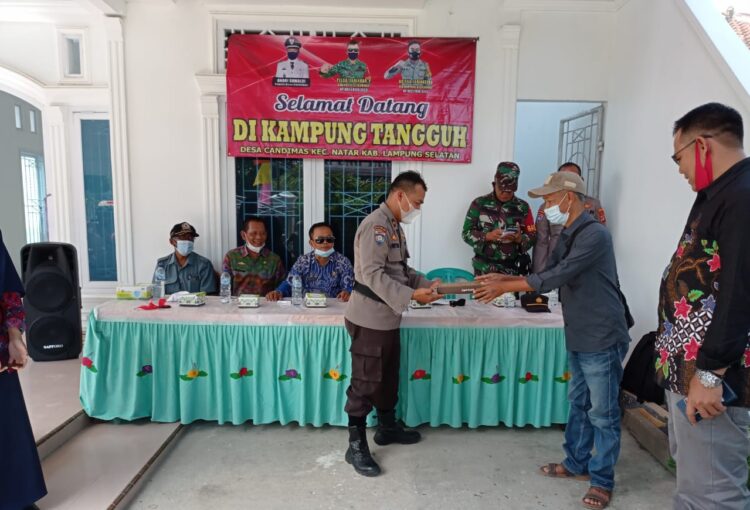 Direktorat Pembinaan Masyarakat Polda Lampung memberikan suvenir sajadah usai sosialisasi pilar kebangsaan di Desa Candimas, Natar. (Lampost.co/Febi Herumanika)