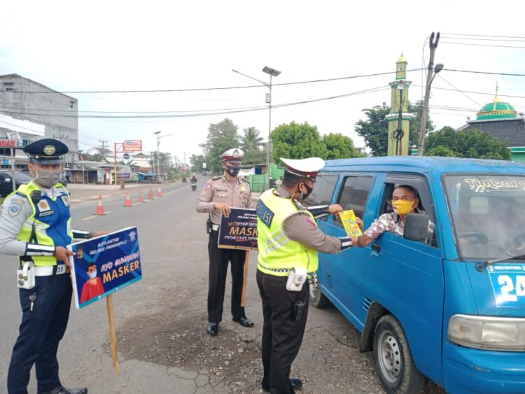 Polres Pringsewu yang tergabung dalam satuan tugas operasi keselamatan Krakatau 2021 membagikan pamflet berisi himbauan larangan mudik dan taat prokes di jalinbar tugu gajah Pringsewu, Rabu 14 April 2021. Istimewa