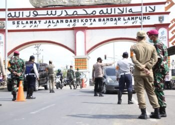 Tim Patroli Satuan Tugas (Satgas) Penanganan Covid-19 Kota Bandar Lampung melakukan penyekatan dan memeriksa kendaraan luar kota yang akan memasuki Kota Bandar Lampung di Rajabasa, Bandar Lampung, Kamis (29/4).
(LAMPUNG POST/ZAINUDDIN)