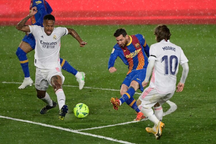 REAL MADRID VS BARCELONA. Bek Real Madrid Eder Militao (kiri) dan gelandang Real Madrid Luka Modric berusaha menghalangi penyerang Barcelona Lionel Messi (tengah) dalam pertandingan sepak bola Liga Spanyol bertajuk El Clasico antara Real Madrid CF dan FC Barcelona di Stadion Alfredo di Stefano, Valdebebas, Madrid, Minggu (11/4).  Real Madrid menguasai puncak klasemen Liga Spanyol setelah memenangi El Clasico dengan skor 2-1.
AFP/JAVIER SORIANO