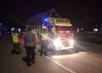 PERIKSA KENDARAAN. Petugas gabungan memeriksa kelengkapan truk yang melintas di Jalan Lintas Timur Sumatera perbatasan Mesuji, Lampung, dengan Ogan Komering Ilir (OKI), Sumatera Selatan, terpantau lengang, Senin (10/5) malam. Arus kendaraan yang melintas mulai lengang menjelang Idulfitri. DOK SATLANTAS POLRES MESUJI