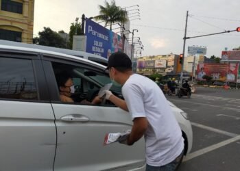 Lampung Post promosi multiplatform kepada masyarakat yang melintas di Tugu Adipura, Bandar Lampung, Minggu (23/5). LAMPUNG POST