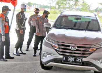 Petugas menghentikan kendaraan untuk memeriksa surat bebas Covid-19 di pos penyekatan jalan tol trans-Sumatera Rest Area 87B Desa Fajarbaru, Kecamatan Jatiagung, Lampung Selatan, Kamis (27/5). (LAMPUNG POST/SUKISNO)