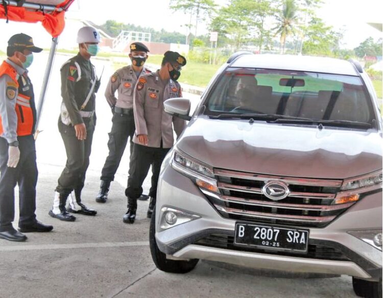 Petugas menghentikan kendaraan untuk memeriksa surat bebas Covid-19 di pos penyekatan jalan tol trans-Sumatera Rest Area 87B Desa Fajarbaru, Kecamatan Jatiagung, Lampung Selatan, Kamis (27/5). (LAMPUNG POST/SUKISNO)