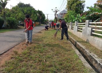 BERSIHKAN LINGKUNGAN. Sekelompok anggota Pemuda Batak Bersatu (PBB) Metro yang membersihkan lingkungan di Jalan Kapten Harun, Kelurahan Imopuro, Metro Pusat, Minggu (6/6). LAMPUNG POST/BAMBANG PAMUNGKAS