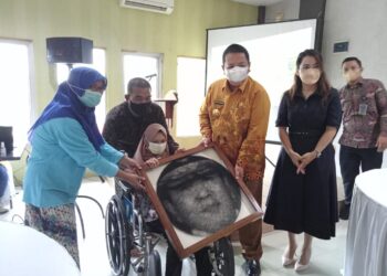 LUKISAN WAJAH. Gubernur Lampung Arinal Djunaidi menerima lukisan wajahnya dengan metode string art karya Sinta Meliyana, gadis 22 tahun penyandang disabilitas Cerebral Palsy Metro, Kamis (3/6). n LAMPUNG POST/BAMBANG PAMUNGKAS