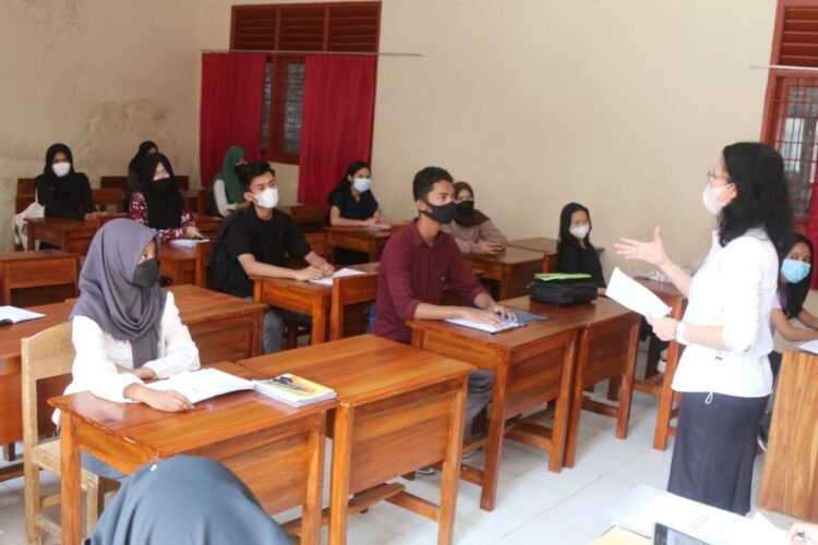 TUGAS DARING SISWA. Seorang guru sedang menerangkan mata pelajaran kepada para siswa terkait tugas daring di SMA Negeri 10 Bandar Lampung, Rabu (9/6).  Kemenkes menargetkan hingga akhir Juni 2021 setidaknya 80% guru dan tenaga pendidikan sudah menerima vaksin. Program vaksinasi tahap II untuk pelayan publik seperti guru dan lansia sempat terkendala stok vaksin. Tetapi, saat ini stok vaksin cukup dan akan diprioritaskan kepada guru dan tenaga pendidik.
n LAMPUNG POST/SUKISNO