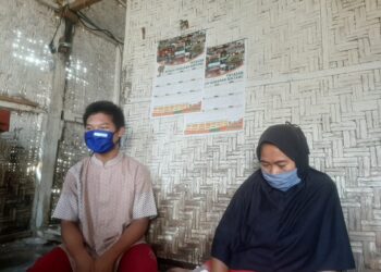 Misnawati (40) bersama salah satu dari tiga anaknya saat di gubuk sewaannya yang berukuran 4 x 6 meter di Jalan Sultan Haji, Gang Cempedak, Sepangjaya, Labuhanratu, Bandar Lampung, Rabu (23/6). (LAMPUNG POST/SALDA ANDALA)