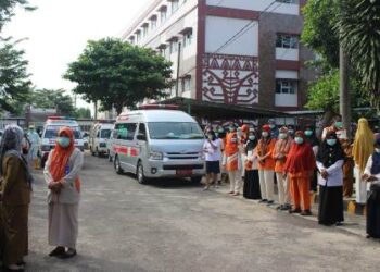 Pegawai Rumah Sakit Umum Darah Ahmad Yani Metro memberikan penghormatan terakhir kepada Susilowati, tenaga kesehatan RSUD setempat yang meninggal karena terpapar Covid-19 saat pelepasan jenazah di pelataran parkir RSUD Ahmad Yani Metro, Rabu (29/6).  (LAMPUNG POST/BAMBANG PAMUNGKAS)