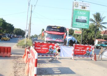 Petugas Gugus Tugas Covid-19 Kota Bandar Lampung mengarahkan kendaraan yang keluar dari pintu tol Kota Baru ke arah Jalan Airan Raya, Jatiagung, Lampung Selatan, Minggu (25/7). Jalan Ryacudu yang merupakan salah satu akses masuk ke Kota Bandar Lampung ditutup saat pemberlakuan pembatasan kegiatan masyarakat (PPKM) darurat di Kota Bandar Lampung.
(LAMPUNG POST/SUKISNO)