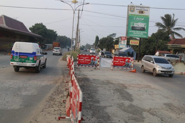 LINTASI PENYEKATAN. Kendaraan melintasi penyekatan Jalan Ryacudu yang merupakan salah satu akses masuk ke Kota Bandar Lampung dari pintu tol Kota Baru, Lampung Selatan, setelah dilonggarkan PPKM level IV, Jumat (30/7).
n LAMPUNG POST/SUKISNO