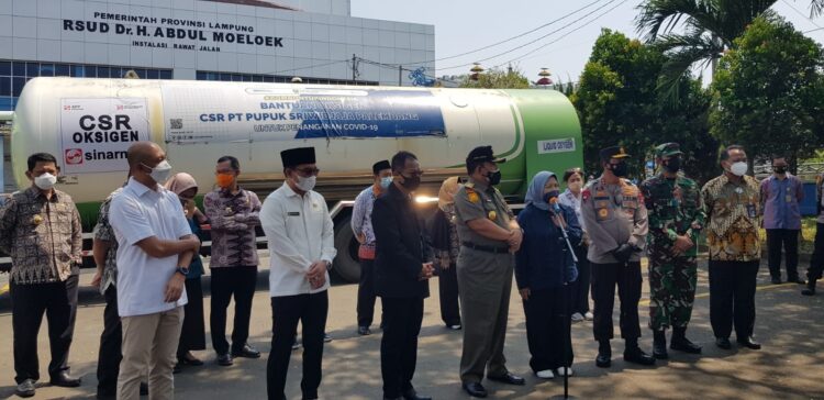 BANTUAN OKSIGEN DAN PERISAPAN ASRAMA HAJI UNTUK ISOLASI. Gubernur Lampung Arinal Djunaidi bersama Kapolda Lampung Irjen Hendro Sugiatno, Ketua DPRD Lampung Mingrum Gumay, Direktur Utama PT Pupuk Sriwidjaja Palembang, Tri Wahyudi  dan Direktur Utama PT Pertamina Bina Medika IHC, Fathema Djan Rachmat saat menerima bantuan liquid oxygen atau oksigen cair dari  PT Pupuk Sriwidjaja Palembang di halaman parkir RSUD Abdul Moeloek Bandar Lampung, Kamis (29/7).  LAMPUNG POST