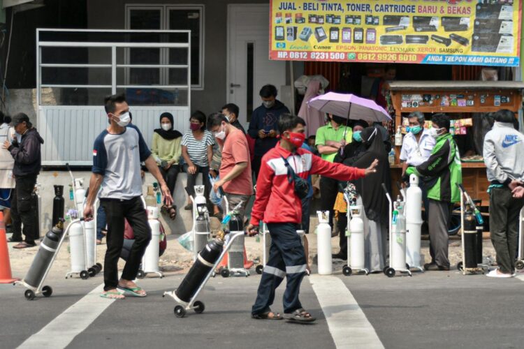 Warga membawa tabung oksigen usai melakukan pengisian ulang oksigen medis yang dibagikan secara gratis di kawasan Manggarai, Jakarta. (MI/Andri Widiyanto)