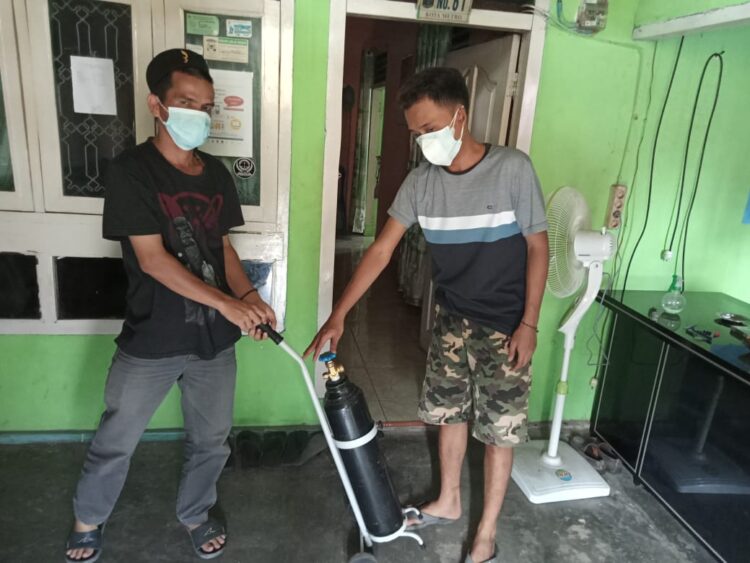 Ketua RW 01 Kelurahan Imopuro, Khairul Anwar saat menunjukkan tabung oksigen yang siap sedia dipergunakan untuk warga yang melakukan isolasi mandiri. Lampost.co/Bambang Pamungkas