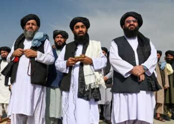 Juru bicara Taliban Zabihullah Mujahid (tengah) berbicara dalam sebuah konferensi pers di bandara Kabul, 31 Agustus 2021, usai kepergian pasukan terakhir AS dari Afghanistan. (Wakil Kohsar/AFP)