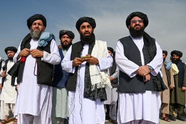 Juru bicara Taliban Zabihullah Mujahid (tengah) berbicara dalam sebuah konferensi pers di bandara Kabul, 31 Agustus 2021, usai kepergian pasukan terakhir AS dari Afghanistan. (Wakil Kohsar/AFP)