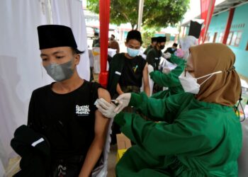 Seorang santri menerima suntikan vaksin Covid-19 saat vaksinasi massal bagi peserta didik dan pengajar di Pondok Pesantren Madarijul Ulum, Bandar Lampung, Lampung, Senin (6/9). (ANTARA FOTO/ARDIANSYAH)