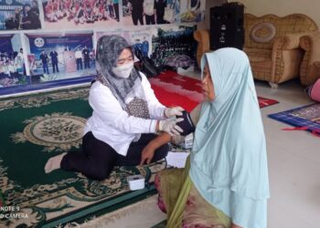 Seorang petugas medis saat melakukan pemeriksaan kesehatan bagi warga korban banjir di Kampung Barangbang Rangkasbitung, Kabupaten Lebak. (dok)