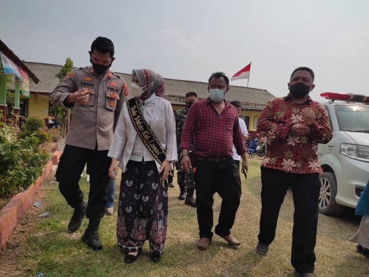 TINJAU VAKSINASI. Duta Vaksin Lampung Selatan Winarni bersama Forkopimcam Tanjungbintang saat meninjau vaksinasi di SDN 1 Sabahbalau, Kecamatan Tanjungbintang, Lampung Selatan, Sabtu (16/10).  LAMPUNG POST/SUKISNO