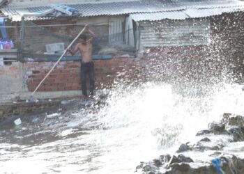 WASPADAI LA NINA. Ombak besar yang melanda pesisir pantai Lampung harus diwaspadai karena dapat menyebabkan banjir rob yang melanda pesisir pantai. Seorang warga sedang membersihkan sampah di samping rumahnya saat terjadi ombak besar di Pantai Sukaraja, Bandar Lampung. Badan Nasional Penanggulangan Bencana (BNPB) memperingatkan seluruh pemerintah daerah bersiap menghadapi dampak La Nina yang akan berlangsung hingga Februari 2022.
LAMPUNG POST/ZAINUDDIN