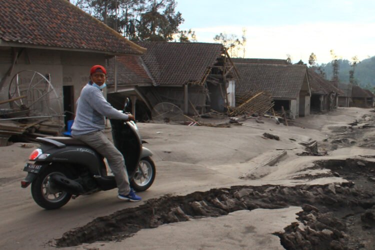 KERUGIAN AKIBAT LETUSAN GUNUNG SEMERU. Seorang warga melintas di depan deretan rumah yang hancur di Desa Supiturang, Lumajang, Jawa Timur, Selasa (7/12). Pusat Kajian Badan Amil Zakat Nasional (Baznas) menghitung kerugian akibat erupsi Gunung Semeru ditaksir mencapai Rp310 miliar yang mencakup sarana prasarana umum serta memengaruhi perekonomian bidang perkebunan, pertanian, peternakan, perdagangan, pertambangan serta pariwisata. ANTARA FOTO/ARI BOWO SUCIPTO