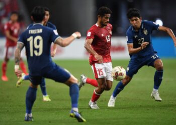 Pemain Timnas Sepak Bola Indonesia Ricky Richardo Kambuaya (tengah) dibayangi dua pemain Thailand, Tristan Do (kiri) dan Weerathep Pomphun (kanan) dalam laga final leg pertama pertandingan Piala AFF Suzuki 2020 di National Stadium, Singapura, Rabu (29/12). Dalam laga ini Timnas Indonesia kalah 0-4 dari Thailand.  (AFP/ROSLAN RAHMAN)
