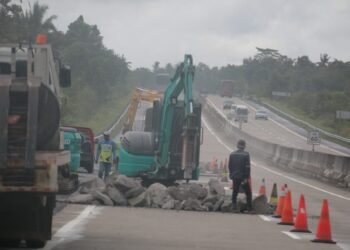 PERBAIKAN JTTS. Pekerja mengoperasikan alat berat memperbaiki ruas jalan tol trans-Sumatera KM 60 Kecamatan Way Sulan, Lampung Selatan, Kamis (20/1). PT Hutama Karya mengatakan kontur tanah yang bergelombang menjadi pemicu kerusakan jalan tol trans-Sumatera (JTTS).
LAMPUNG POST/SUKISNO