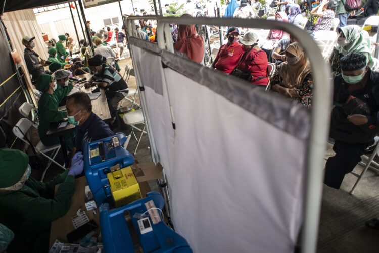 Warga mengantre untuk mendapatkan vaksin COVID-19 dosis ketiga saat vaksinasi booster COVID-19 di Puskesmas Kecamatan Kramat Jati, Jakarta Timur, Jakarta, Rabu (12/1/2022). Pemerintah memulai program vaksinasi lanjutan (booster) COVID-19 secara gratis kepada masyarakat umum yang berusia 18 tahun ke atas dengan kelompok prioritas penerima vaksin adalah orang lanjut usia (lansia) dan penderita immunokompromais. ANTARA FOTO/Aprillio Akbar/YU