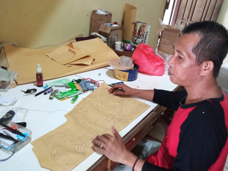 MUHAMAD Yusuf Masroh pemilik Elfira Collection, sedangmenggambar pola untuk pembuatan sulam usus asal Lampung.Lampung Post/ Dian Wahyu K
