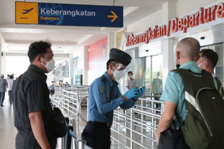 Petugas bandara sedang mengecek kelengkapan data calon penumpang sebelum memasuki Bandara Radin Inten II Lampung Selatan, Jumat (10/3). (LAMPUNG POST/SUKISNO)