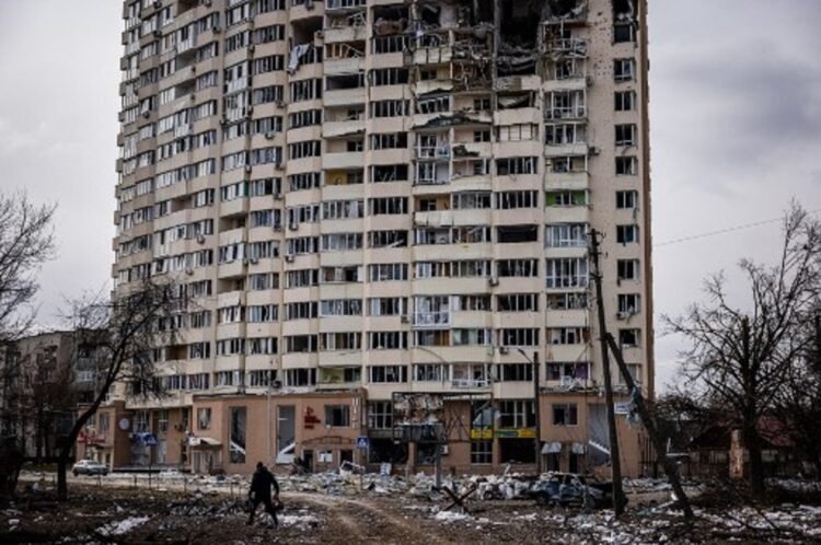 Seorang pria berjalan di depan gedung yang rusak akibat serangan Rusia di kota Chernihiv, Ukraina, 4 Maret 2022. (AFP)