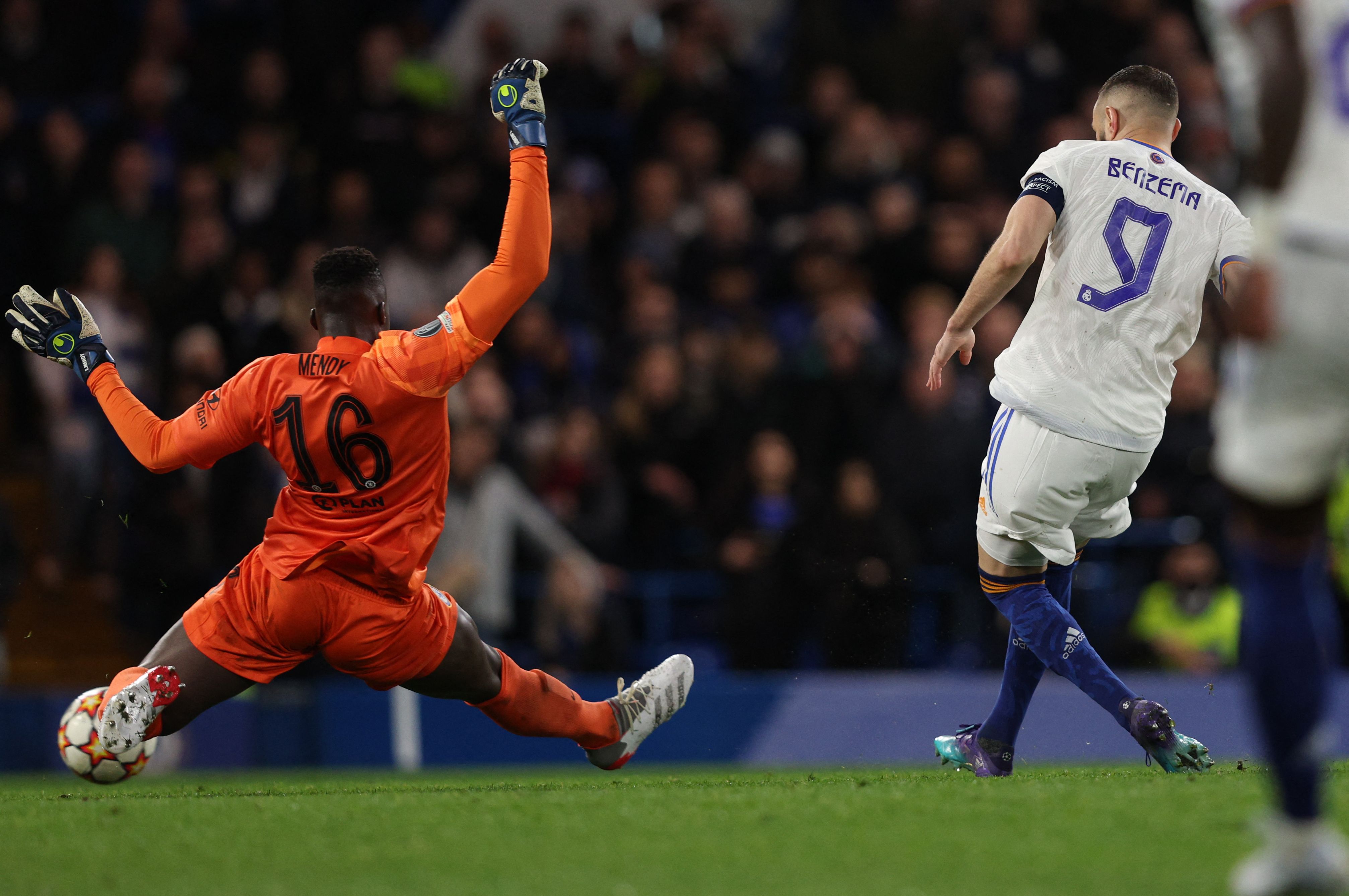 TOPSHOT - Real Madrid's French striker Karim Benzema scores his third goal past Chelsea's French-born Senegalese goalkeeper Edouard Mendy (L) during the UEFA Champions League Quarter-final first leg football match between Chelsea and Real Madrid at Stamford Bridge stadium in London, on April 6, 2022. (Photo by Adrian DENNIS / AFP)