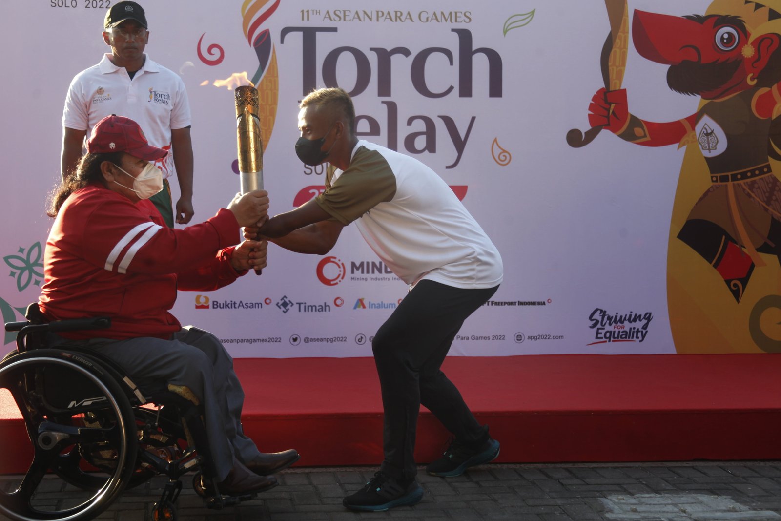 Ketua umum National Paralympic Committee (NPC) Indonesia Senny Marbun (kiri) menyerahkan api obor kepada atlet para atletik Indonesia Rizal Bagus Saktyono (kanan) saai torch relay atau pawai obor ASEAN Para Games 2022 di Stadion Sriwedari, Solo, Jawa Tengah, Minggu (24/7/2022). Indonesia menjadi tuan rumah ajang ASEAN Para Games XI 2022 yang akan mempertandingkan 14 cabang olahraga dan diikuti 11 negara-negara Asia Tenggara pada 30 Juli-6 Agustus 2022 mendatang. ANTARA FOTO/Maulana Surya/foc.
