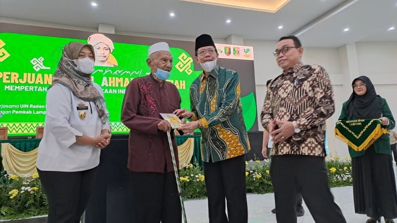 Wagub Lampung Chusnunia Chalim dan Rektor UIN RIL Prof. Wan Jamaluddin memberikan buku biografi KH Ahmad Hanafiah. (LAMPOST/ANDRE)