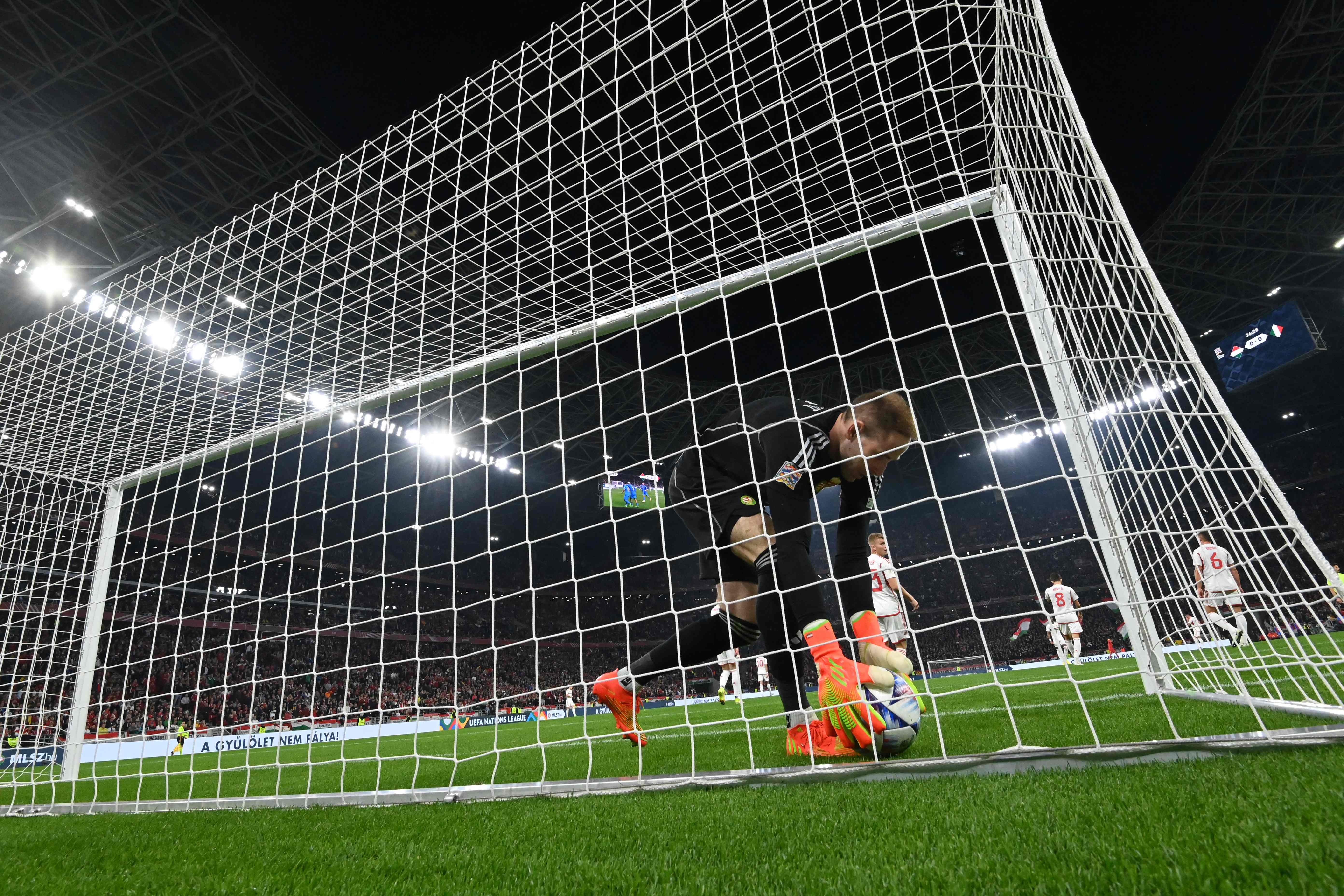 AMBIL BOLA. Penjaga gawang Hongaria, Peter Gulacsi, mengambil bola setelah pemain depan Italia Giacomo Raspadori mencetak gol dalam pertandingan Grup 3 UEFA Nations League antara Hongaria dan Italia di Puskas Arena Park, Selasa (27/9) dini hari WIB.(AFP/ATTILA KISBENEDEK)