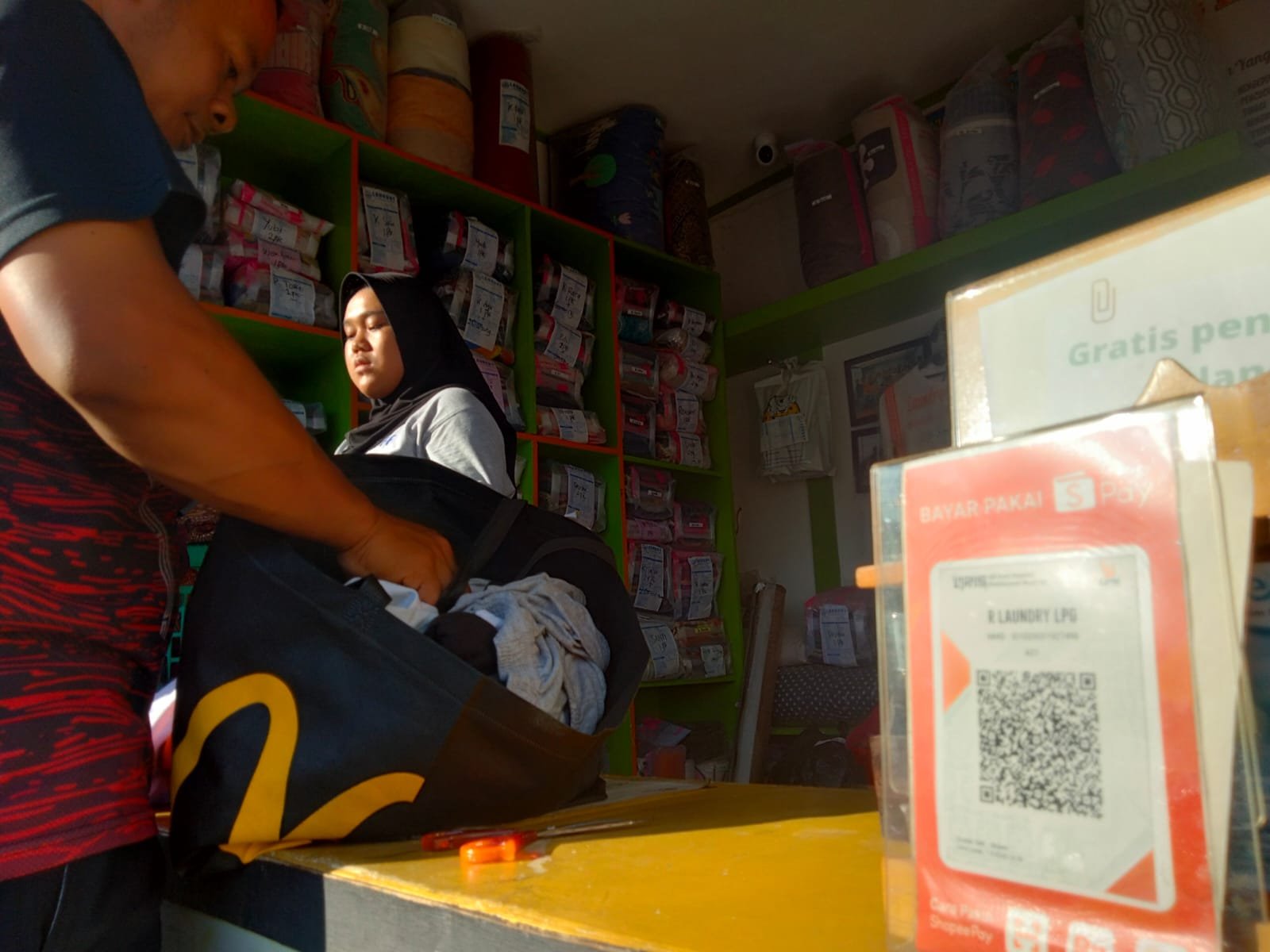 PEMBAYARAN DIGITAL. Salah satu konter laundry yang berada di Jalan Perintis Kemerdekaan, Bandar Lampung, menyiapkan kode QRIS untuk transaksi pembayaran, Minggu (23/10). Masyarakat terus didorong menggunakan sistem pembayaran digital (cashless). Selain meningkatkan literasi digital, juga menghindari peredaran uang palsu.
LAMPUNG POST/ZAINUDDIN