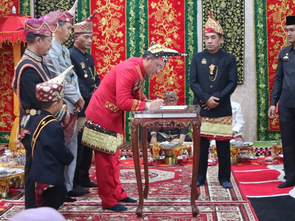 Bupati Lampung Barat Parosil Mabsus dan Ketua DPRD Lampung Barat Edi Novial menandatangani hasil Himpun Adat bersama empat kepaksian dan marga Liwa, Rabu (23/11). (Dok. KOMINFO LAMBAR)