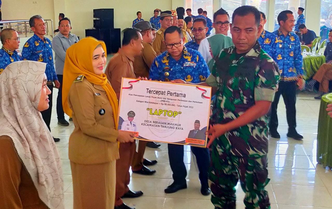 SERAHKAN PENGHARGAAN. Pemerintah Kabupaten Mesuji memberikan penghargaan kepada Desa Berasanmakmur, Kecamatan Tanjungraya, Mesuji, Rabu (21/12). Penghargaan diberikan karena Berasanmakmur menjadi yang terbaik dan tercepat juga overtarget realisasi penarikan pajak bumi dan bangunan tahun 2022.
n LAMPUNG POST/RIDWAN ANNAS