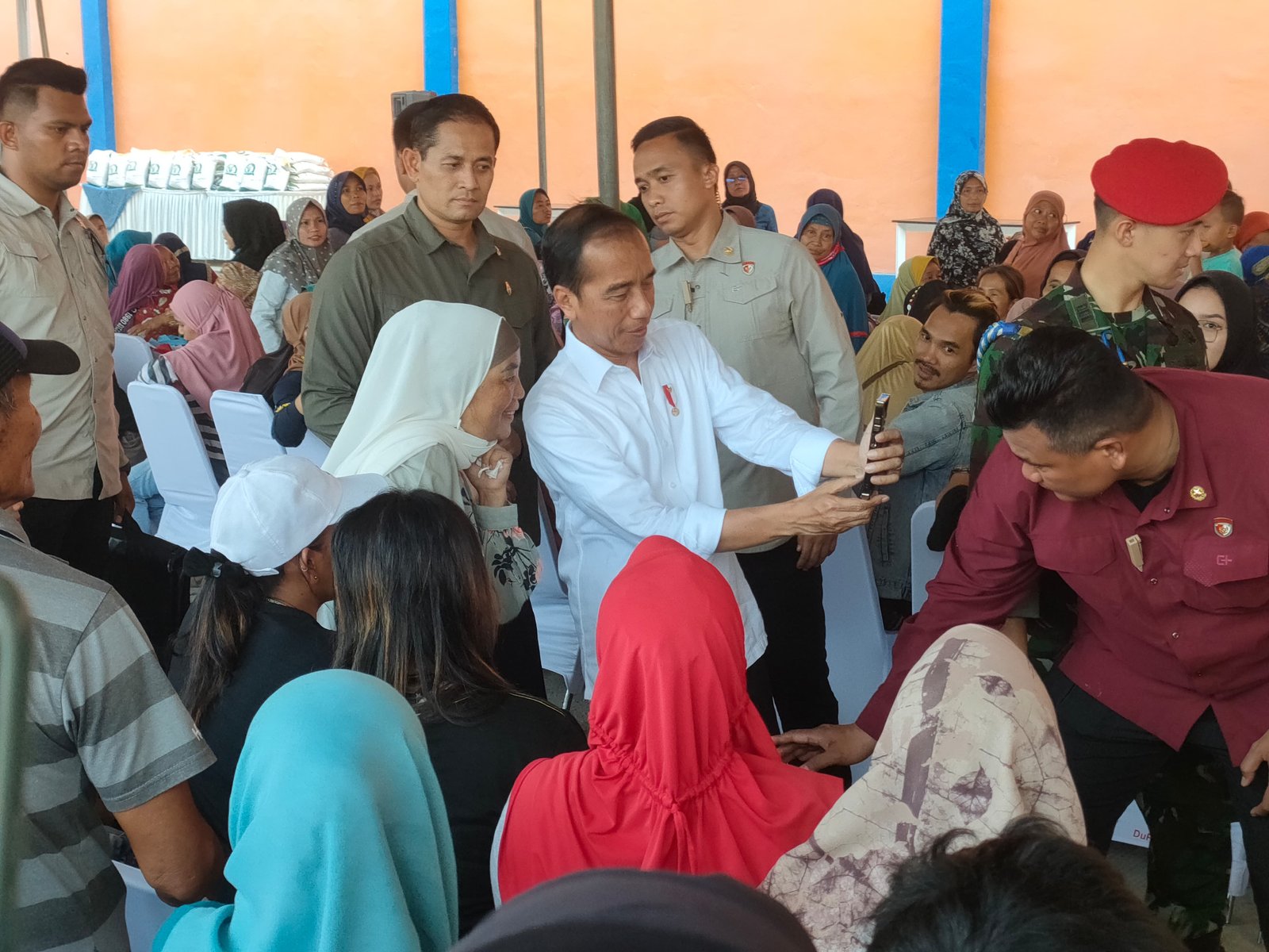 KUNJUNGAN KERJA PRESIDEN KE LAMPUNG. Presiden Joko Widodo melakukan swafoto bersama warga usai membagikan beras bantuan pangan Bapanas tahap II periode September—November 2023 kepada masyarakat sekitar di Gudang Bulog Campangraya, Bandar Lampung, saat kunjungan kerjanya di Lampung, Kamis (26/10).
LAMPUNG POST/SILVIA AGUSTINA