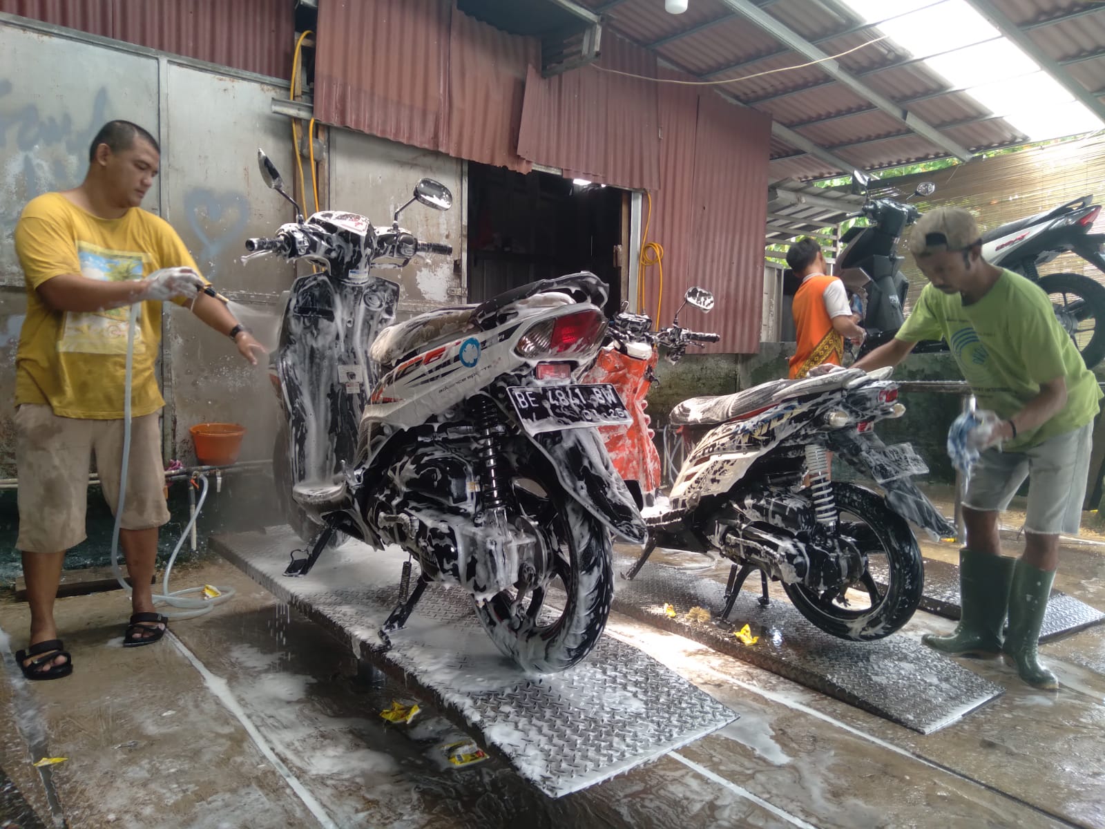 STEAM MOTOR ISYARAT. Pekerja yang merupakan tunarungu dan tunawicara mencuci sepeda motor di Steam Motor Isyarat di Jalan Panglima Polim, Segalamider, Tanjungkarang Barat, Bandar Lampung, Minggu (19/11). Pengelola Steam Motor Isyarat, Dwi Jaya Nugroho, mengungkapkan sengaja mempekerjakan teman-teman berkebutuhan khusus karena ingin memberikan kesempatan dan berbagi kepada mereka agar bisa bekerja.
LAMPUNG POST/ANDI APRIADI