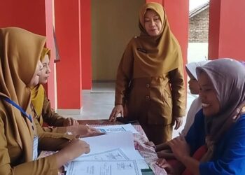 SISTEM PENERIMAAN MURID BARU. Dewan guru SMPN 38 Bandar Lampung memeriksa kelengkapan berkas pendaftaran salah satu peserta Sistem Penerimaan Murid Baru (SPMB), Selasa (24/6). Tahun ini kuota penerimaan peserta didik tingkat SMP sebanyak 14.000 siswa baik untuk negeri dan swasta. Khusus untuk SMP negeri tersedia 11.000 kursi di 45 sekolah di Bandar Lampung. Lampung Post / Umar Robbani