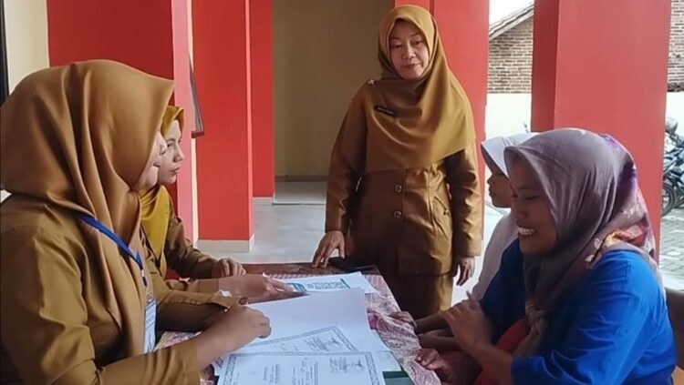 SISTEM PENERIMAAN MURID BARU. Dewan guru SMPN 38 Bandar Lampung memeriksa kelengkapan berkas pendaftaran salah satu peserta Sistem Penerimaan Murid Baru (SPMB), Selasa (24/6). Tahun ini kuota penerimaan peserta didik tingkat SMP sebanyak 14.000 siswa baik untuk negeri dan swasta. Khusus untuk SMP negeri tersedia 11.000 kursi di 45 sekolah di Bandar Lampung. Lampung Post / Umar Robbani