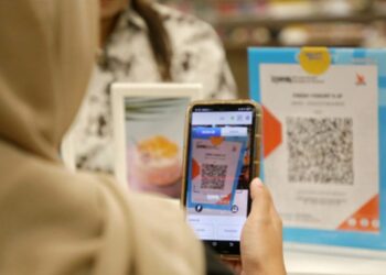 Seorang wanita sedang melakukan transaksi menggunakan QRIS. Dok ANTARA