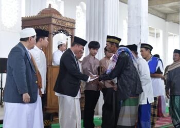Wakil Rektor Teknokrat Dr. H Mahathir Muhammad, SE, MM. didampingi Rektor Dr. H.M. Nasrullah Yusuf, S.E., M.B.A. membagikan zakat, infaq dan sedekah bagi jamaah pria dan anak-anak.