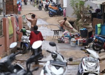 Warga Jalan Pangeran Antasari, Gang Ainan, Kecamatan Kedamaian, Bandar Lampung, mulai membersihkan rumah dari material banjir. Pemukiman wilayah itu terendam banjir bandang pada Sabtu malam, 24 Februari 2024.