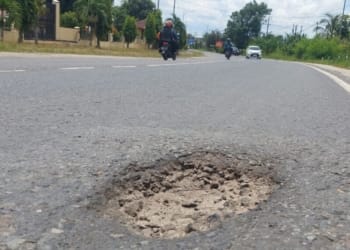Kondisi jalan lintas Sumatra yang berlubang tepat di depan Kantor Pengadilan Agama Lamteng, Kecamatan Gunungsugih.