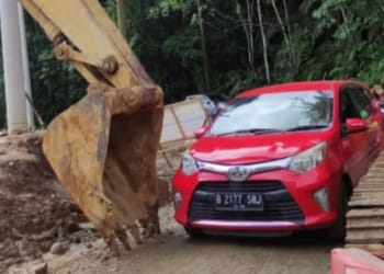 Kendaraan minibus melintas di cela alat berat yang masih melakukan perbaikan jalan di jalur Liwa-Krui, Senin, 8 April 2024. Dok/Kepolisian